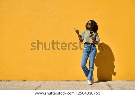 Similar – Image, Stock Photo Young black female standing in studio against yellow and blue lights