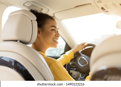 Happy African American Girl Driving Car, Smiling And Looking At Side Mirror, Free Space