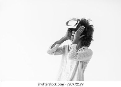 Happy african american girl getting experience using VR headset glasses of virtual reality, isolated on white background - Powered by Shutterstock