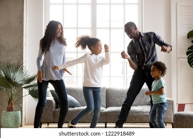 Happy African American Having Fun Together Indoors, Funny Married Couple Dancing With Adorable Little Preschooler Daughter And Cute Toddler Son At Home, Listening To Music, Family Weekend With Kids