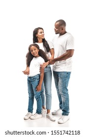 happy african american husband and wife looking at each other while standing near adorable daughter on white background