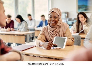 Happy African American Islamic student and her friend e-learning on touchpad during a lecture at the university. - Shutterstock ID 2144215589