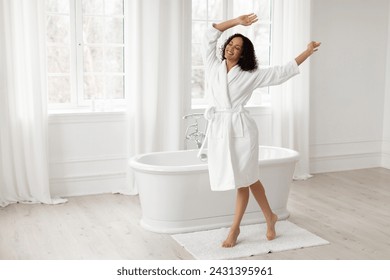 Happy african american lady dancing having fun enjoying morning beauty care routine in bathroom, full length shot, free space - Powered by Shutterstock