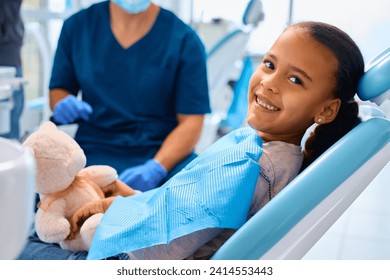 Happy African American little girl during teeth check-up at dentist's office. - Powered by Shutterstock