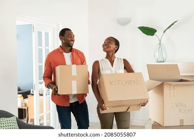 Happy african american man and beautiful woman during moving house. Newly wed married black couple shifting home. Excited middle aged couple holding cardboard boxes while moving to new home. - Powered by Shutterstock