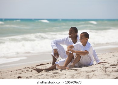 A Happy African American Man And Boy, Father And Son, Family Together On A Tropical Beach In Summer Sunshine