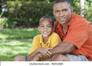 A Happy African American Man And Boy, Father And Son, Family Together Outside In Summer Sunshine