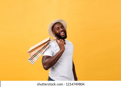 Happy African American Man Holding Shopping Bags On Yellow Background. Holidays Concept