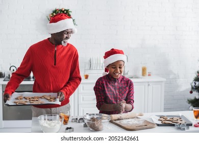 Happy African American Man Holding Baking Sheet With Christmas Cookies Near Grandson