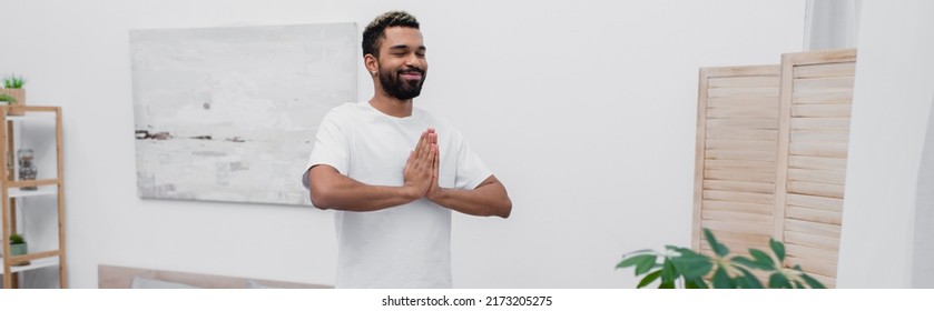 Happy African American Man African American Man Meditating With Praying Hands Near Folding Screen, Banner