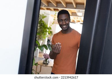 Happy African American Man Standing In Doorway And Inviting Inside The House. Spending Quality Time At Home Alone.