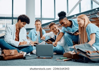 Happy African American medical student and his friends cooperating while e-learning on laptop in lecture hall.  - Powered by Shutterstock