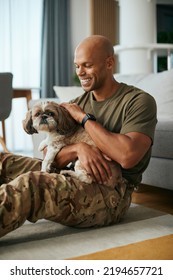 Happy African American Military Man Enjoying With His Dog At Home. 