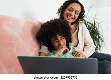 Happy African American Mother And Daughter Watching Comedy Movie On Laptop