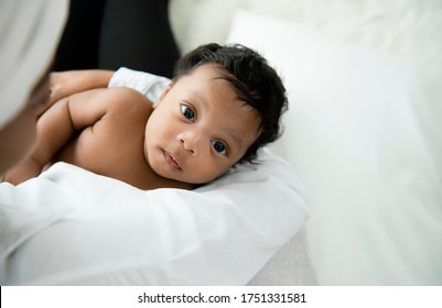 Happy African American mother holding baby boy portrait and looking at camer on white background. Adorable little african american baby boy In the embrace of mother. Happy black family with newborn.