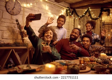 Happy African American multigeneration family having fun while taking selfie at dining table on Thanksgiving. - Powered by Shutterstock