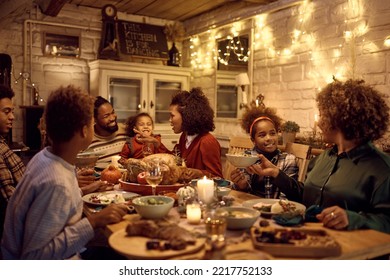 Happy African American multigeneration family talking while eating at dining table on Thanksgiving.  - Powered by Shutterstock