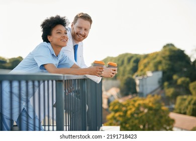 Happy African American Nurse And Male Doctor Having Coffee Break On A Terrace. Copy Space. 