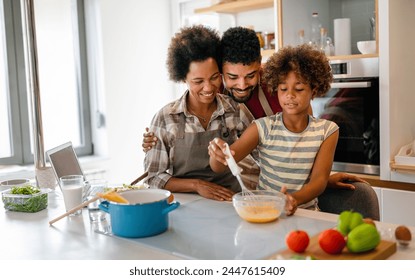 Happy african american parents and child having fun preparing healthy food in kitchen - Powered by Shutterstock