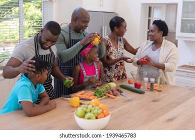 Happy african american parents cooking with son and daughter and grandparents in the kitchen. three generation family spending quality time together. - Powered by Shutterstock