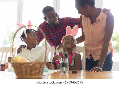 Happy african american parents with son and daughter wearing bunny ears painting colourful eggs. celebrating easter at home in isolation during quarantine lockdown. - Powered by Shutterstock