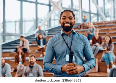 Happy African American presenter an education event in conference hall and looking at camera. - Powered by Shutterstock