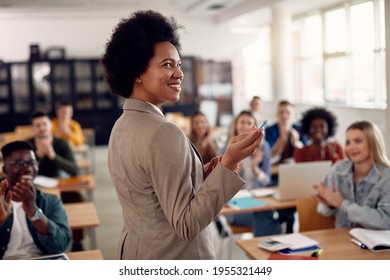 Happy African American professor receives applause from her students while lecturing them in the classroom. - Shutterstock ID 1955321449