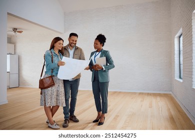 Happy African American real estate agent and her clients analyzing blueprints of a new house. Copy space.  - Powered by Shutterstock