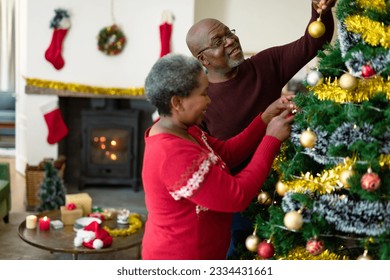 Happy african american senior couple decorating christmas tree at christmas time. retirement lifestyle and christmas festivities, celebrating at home. - Powered by Shutterstock