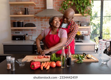 Happy african american senior couple cooking together in kitchen. retirement lifestyle, leisure and spending time at home. - Powered by Shutterstock