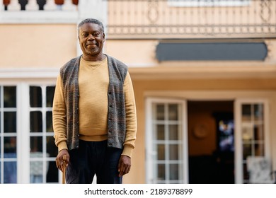 Happy African American Senior Man Standing In Front Of Nursing Home And Looking At Camera. Copy Space.