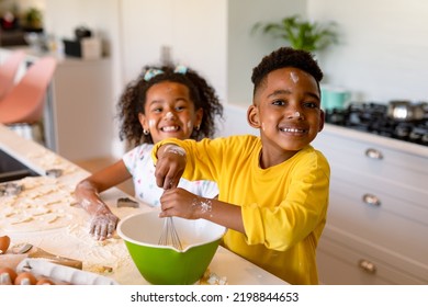 Happy african american siblings baking in kitchen. baking and cooking, childhood and leisure time at home. - Powered by Shutterstock