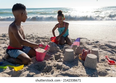 Happy african american siblings making sandcastle together at beach on sunny day. unaltered, family, childhood, togetherness, enjoyment and holiday concept. - Powered by Shutterstock