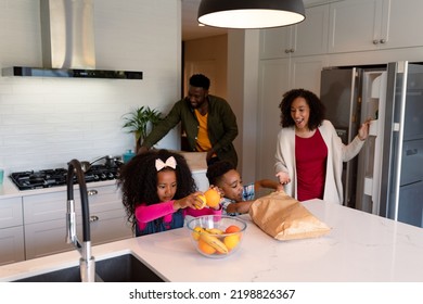 Happy African American Siblings Unpacking Groceries With Parents In Kitchen. Family Time, Having Fun Together At Home.