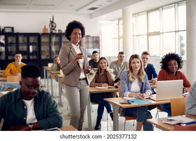 Happy African American teacher giving lecture to her students at university classroom.  - Shutterstock ID 2025377132