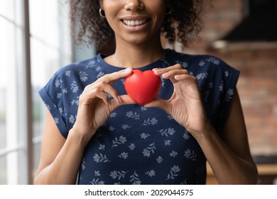 Happy African American Volunteer Girl Holding Red Heart, Showing Object At Camera, Smiling. Black Young Woman Promoting Charity, Donation Campaign, Health Insurance, Medical Checkup. Close Up Of Hands