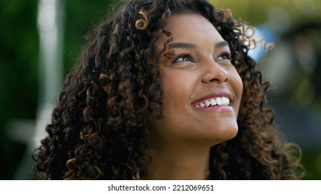 Happy African American Woman Closeup Face Looking Up At Sky Smiling. One Hopeful Black Hispanic 20s Adult Girl