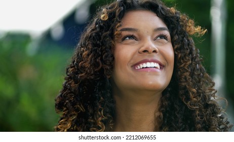 Happy African American Woman Closeup Face Looking Up At Sky Smiling. One Hopeful Black Hispanic 20s Adult Girl