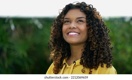 Happy African American Woman Closeup Face Looking Up At Sky Smiling. One Hopeful Black Hispanic 20s Adult Girl