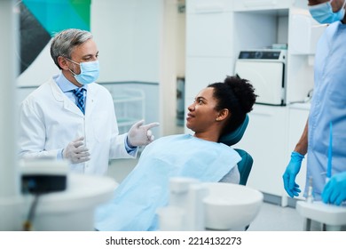 Happy African American Woman Communicating With Her Dentist During Appointment At Dental Clinic.