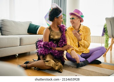 Happy African American Woman And Her Male Friend Wearing Mardi Gras Carnival Costumes And Talking At Home Party. 