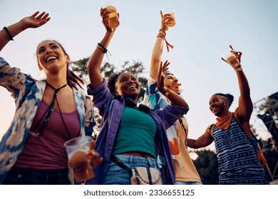 Happy African American woman and her friends attending open air summer music festival. - Powered by Shutterstock