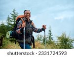 Happy African American woman hiking in the mountains and looking at camera. Copy space.