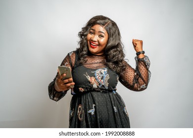 Happy African American woman holding a phone - celebration
