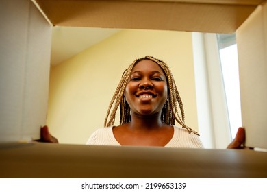 Happy African American Woman Looking Inside Of Box And Surprised Of Cute Pet