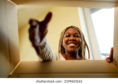 Happy African American Woman Looking Inside Of Box And Surprised Of Cute Pet