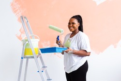Happy African American Woman Painting Wall In Her New Apartment. Renovation, Redecoration And Repair Concept.