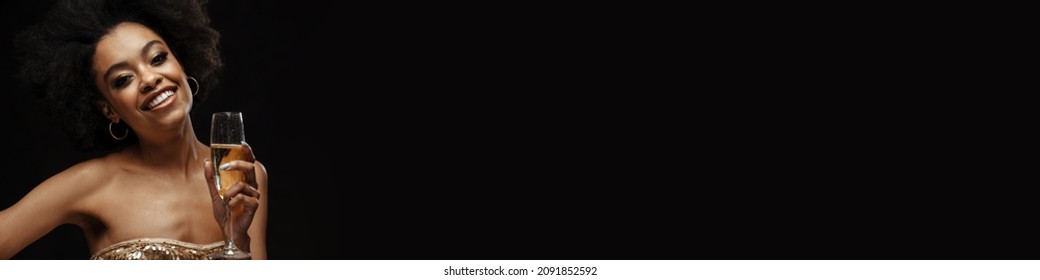 Happy African American Woman In Party Dress Drinking Champagne Isolated Over Black Background