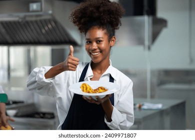 Happy African American woman standing with thump up while working as chef in a restaurant. Cooking class. culinary classroom. happy young african woman students cooking in cooking school.  - Powered by Shutterstock