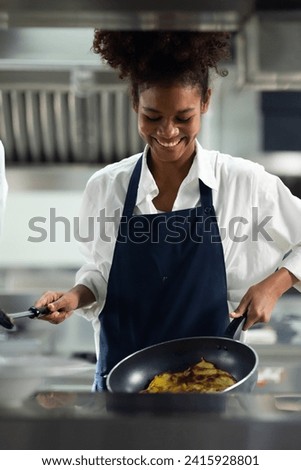 Happy African American woman standing with arms crossed while working as chef in a restaurant. Cooking class. culinary classroom. happy young african woman students cooking in cooking school. 